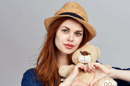 cheerful woman in a hat with a teddy bear gift toyの写真素材