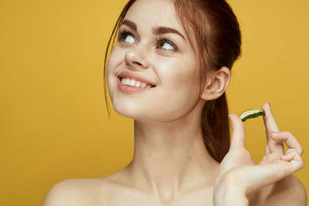 cheerful woman with cucumber vitamin skin care natural productの写真素材