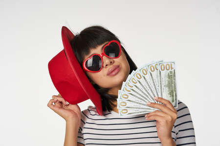 woman in a striped t-shirt wearing glasses with money in hands wealth financeの写真素材