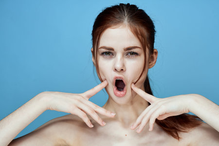 woman with bared shoulders pigtail emotions posing blue background