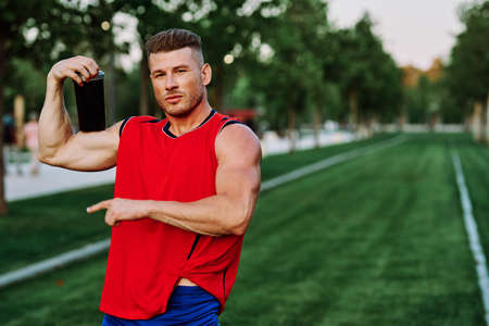sporty man in red jersey muscle workout parkの写真素材