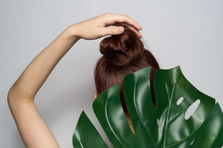attractive woman palm leaf bare shoulders isolated backgroundの写真素材