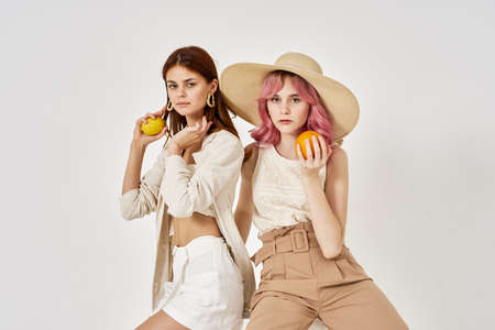 two girlfriends stand side by side fashion clothing glamor posingの写真素材