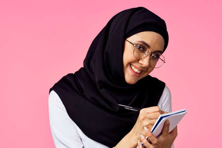 muslim woman with calculator and finance money pink backgroundの写真素材