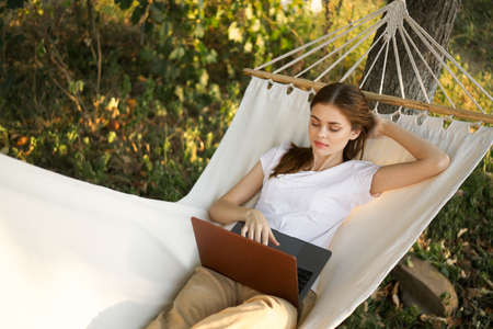 woman lies on a hammock with laptop travel vacation internetの写真素材