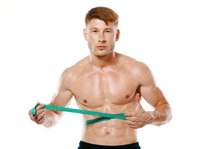 athletic man with measuring tape muscle workoutの写真素材