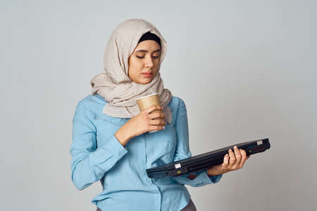 muslim woman in hijab with laptop coffee cup workの写真素材