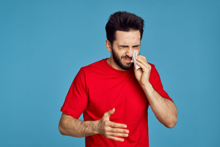 man in red t-shirt health problems emotions symptoms blue backgroundの写真素材