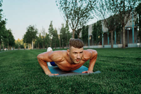 sports muscular man doing fitness crossfit in the parkの写真素材