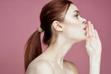 woman with bare shoulders charm cosmetics pink background posingの写真素材