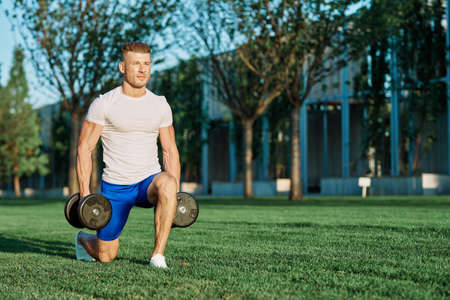 athletic man training with dumbbells in the morning Parkの写真素材