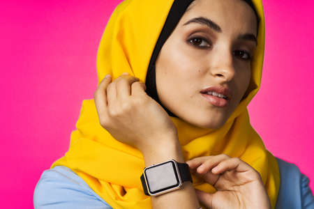 muslim woman with smart watch technology posing pink backgroundの写真素材