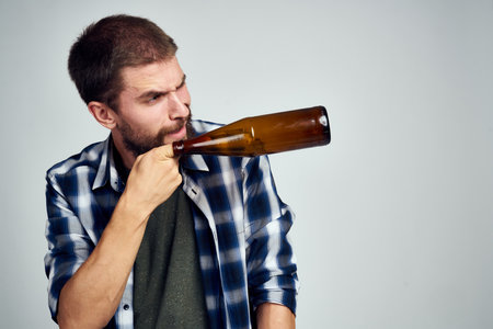 a man in a plaid shirt drinking beer alcohol emotion isolated backgroundの写真素材