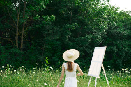pretty woman in white dress outdoors easel artの写真素材
