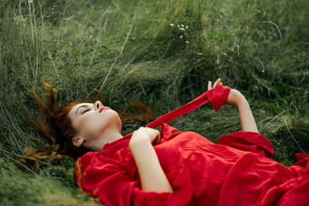 pretty woman in red dress lies on the grass in the field nature fresh air