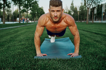sports muscular man doing fitness crossfit in the park