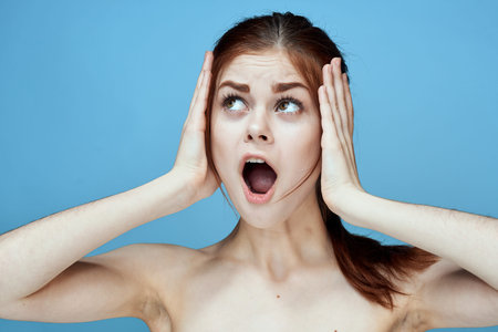 woman with bared shoulders pigtail emotions posing blue background