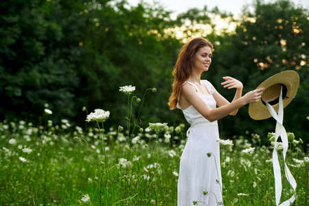 Woman in white dress hat nature field flowersの写真素材