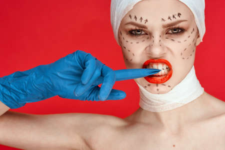 beautiful woman posing in blue gloves red lips surgery facial rejuvenation studio lifestyleの写真素材