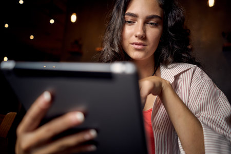 woman sitting in cafe in front of laptop working technology