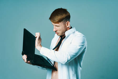 a man in a shirt with a pumped-up body laptop dumbbells business officeの写真素材