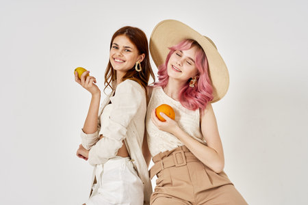 two girlfriends stand side by side fashion clothing glamor posingの写真素材