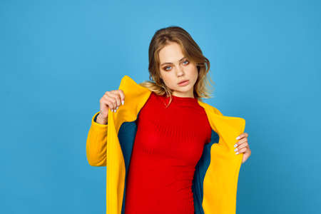 woman in yellow jacket posing makeup fashion blue backgroundの写真素材