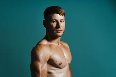 athletic man with pumped up muscular body workout green backgroundの写真素材