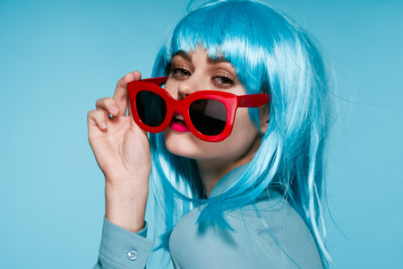 attractive woman in purple wig red glasses posing close-upの写真素材