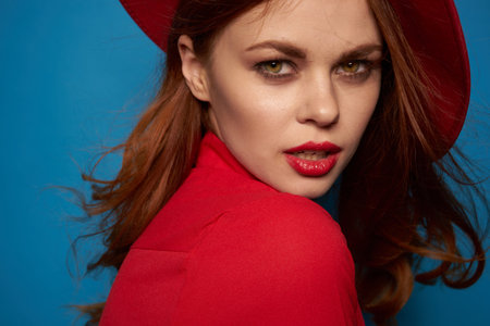 beautiful woman wearing a red hat cosmetics posing blue background