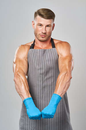 sports man in rubber gloves apron cleaning serviceの写真素材