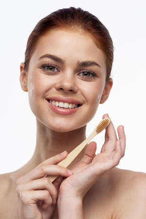 cheerful woman with bare shoulders toothbrushes hygiene oral careの写真素材