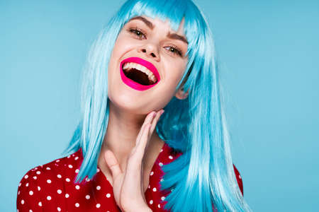 joyful woman in purple wig glamor posing blue backgroundの写真素材