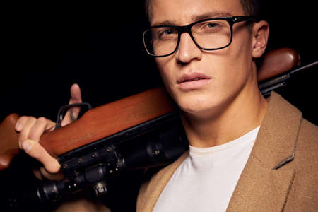 Man with a gun in hand security hunter dark backgroundの写真素材