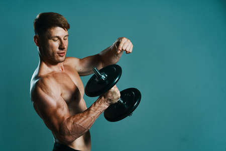 athletic man with dumbbells in hands pumping up muscles workoutの写真素材