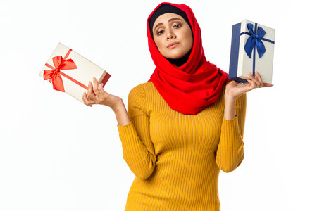 cheerful muslim woman shopping holiday gifts light background
