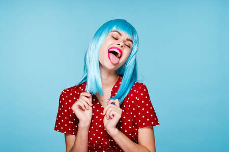 emotional woman in red dress blue wig red lips fashionの写真素材