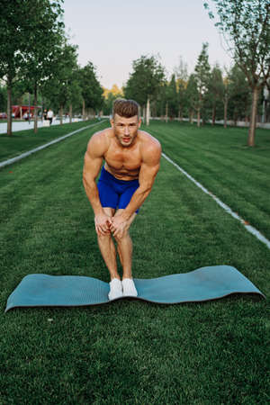 sporty man in shorts in the park working out outdoorsの写真素材