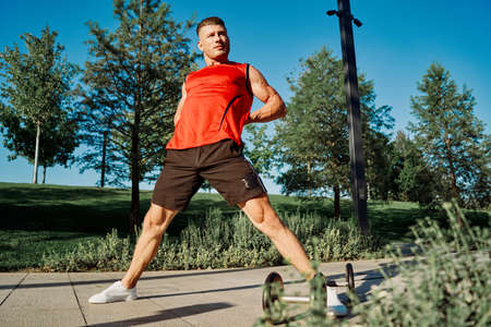 sporty man workout dumbbells exercise outdoors in the parkの写真素材