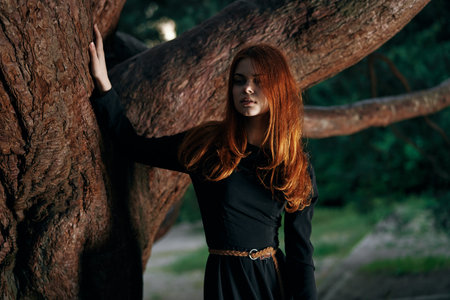woman in black dress nature walk garden trees fresh airの写真素材
