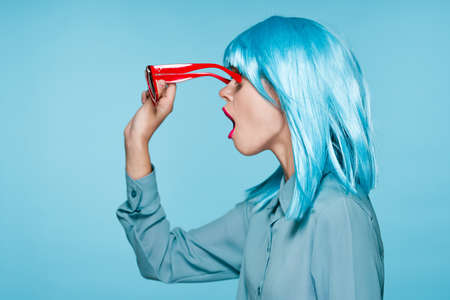 attractive woman in purple wig red glasses posing close-upの写真素材