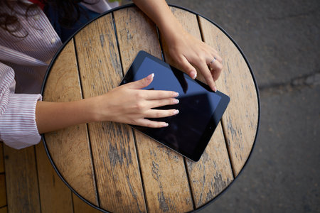 wooden table outdoor cafe tablet work lifestyleの写真素材