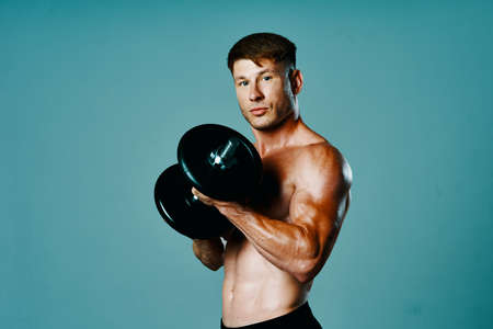 bodybuilder with a muscular body with dumbbells in his hands fitnessの写真素材