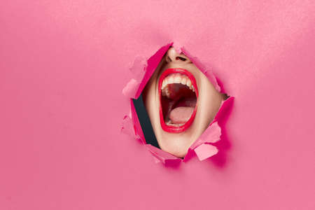 cheerful woman poster hole pink background and red lipsの写真素材