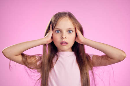 cute girl with long hair on pink background lifestyle childhoodの写真素材