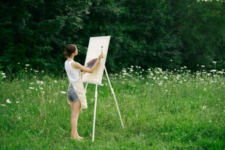 woman artist in aprons paint palette easel natureの写真素材