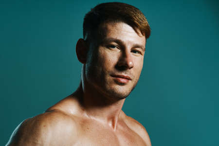 athletic man with pumped up muscular body workout green backgroundの写真素材