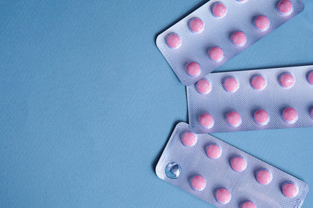 pink pills in packs vitamins pain reliever blue background