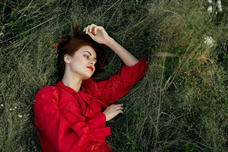 woman in red dress lies on the grass nature freedom summerの写真素材