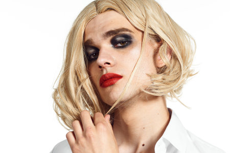 man in a womans wig in a white shirt womens cosmetics shemaleの写真素材